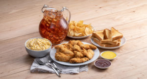 Slim Chickens crowd pack catering with tenders, mac and cheese, toast, chips, sweet tea, and sauces